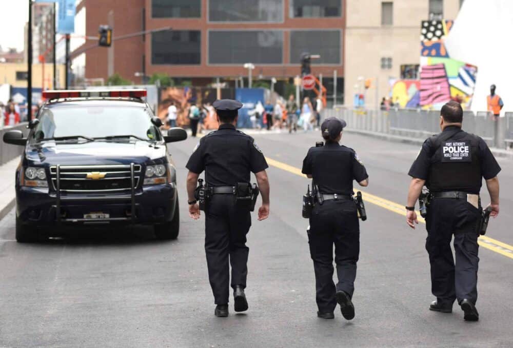 Police officers walking down a street observing a street held event